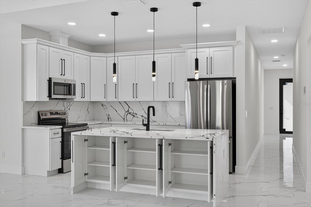 2719 West St John Street Tampa, FL 33607 - Photo 16 of 44 a kitchen with kitchen island granite countertop a sink appliances and cabinets