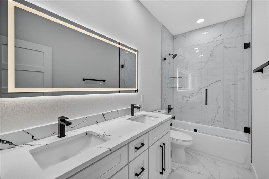 2719 West St John Street Tampa, FL 33607 - Photo 27 of 44 a bathroom with a double vanity sink toilet mirror and bathtub