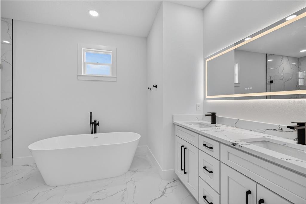 2719 West St John Street Tampa, FL 33607 - Photo 32 of 44 a bathroom with a white tub a sink and mirror