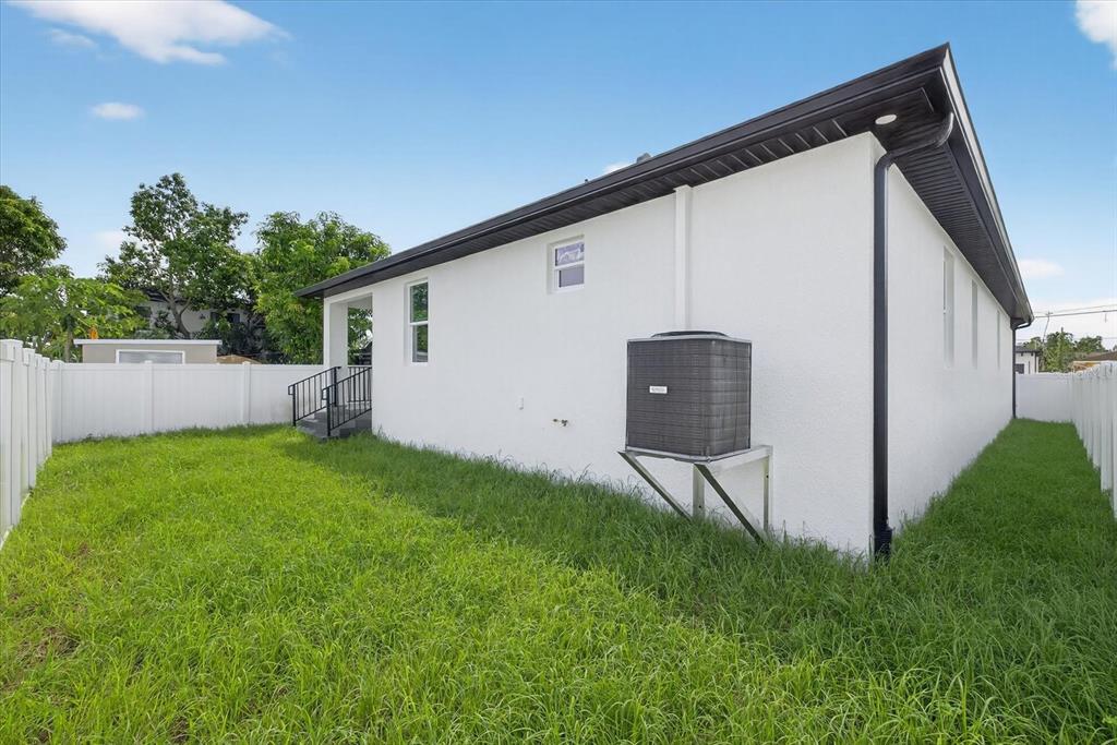 2719 West St John Street Tampa, FL 33607 - Photo 44 of 44 a backyard of a house with lawn chairs and plants