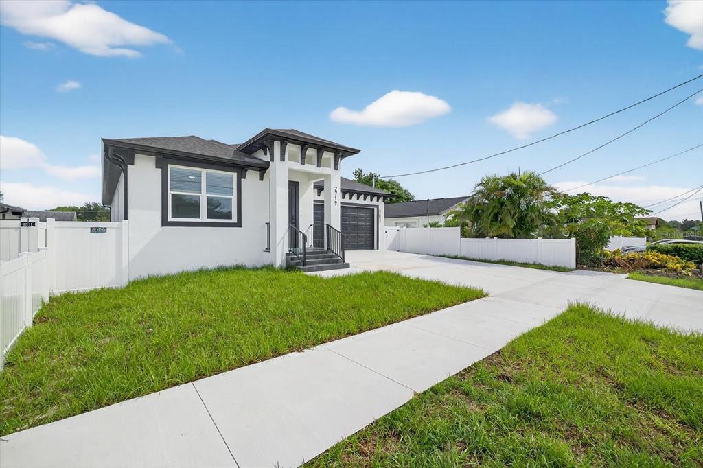 2719 West St John Street Tampa, FL 33607 - Photo 5 of 44 a front view of a house with a yard and potted plants