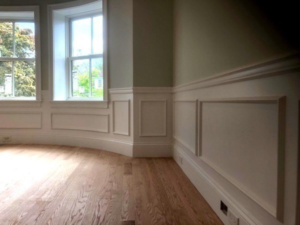 43 Addington Road, Unit 3 Brookline, MA 02445 - Photo 11 of 24 an empty room with wooden floor and windows with curtains