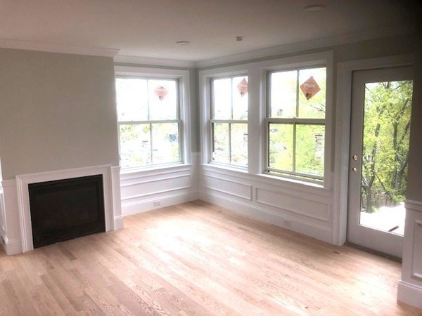 43 Addington Road, Unit 3 Brookline, MA 02445 - Photo 9 of 24 a view of an empty room with a fireplace and a window