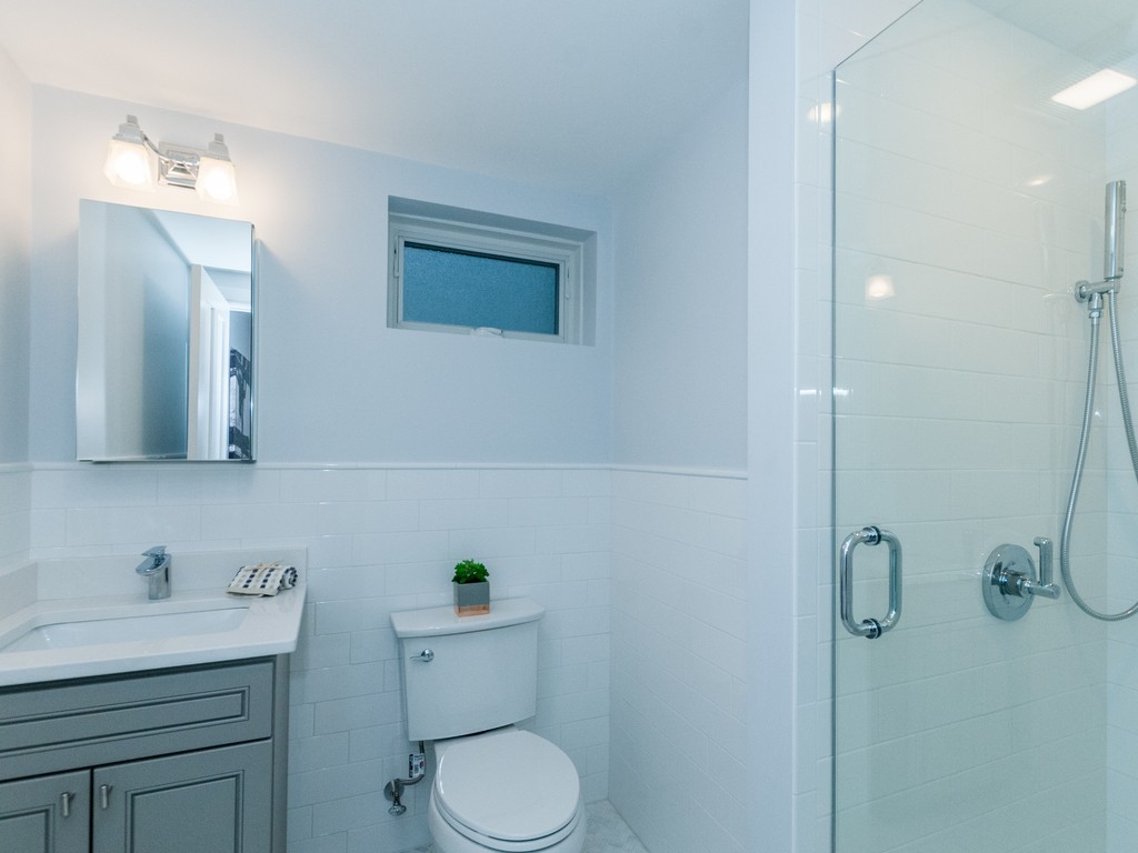 59 Bradford Road, Unit 2 Watertown, MA 02472 - Photo 11 of 20 a bathroom with a granite countertop toilet sink and mirror