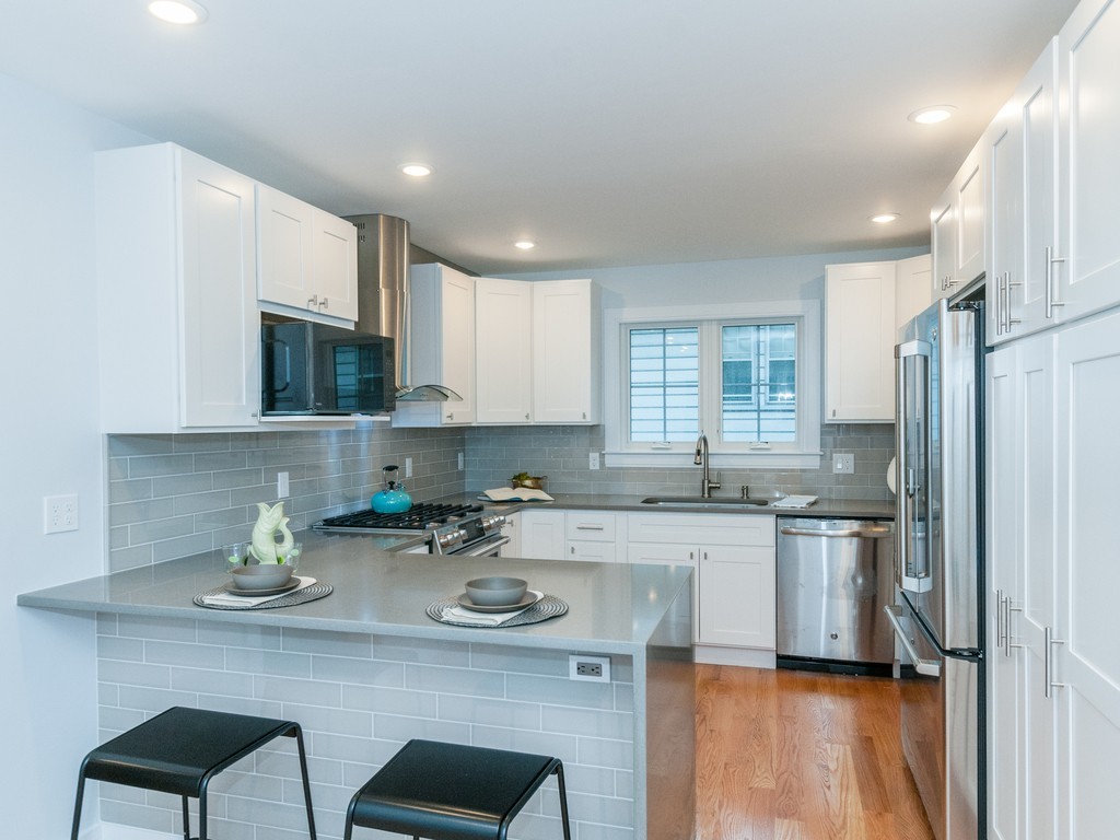 59 Bradford Road, Unit 2 Watertown, MA 02472 - Photo 5 of 20 a kitchen with stainless steel appliances granite countertop a sink stove refrigerator and cabinets
