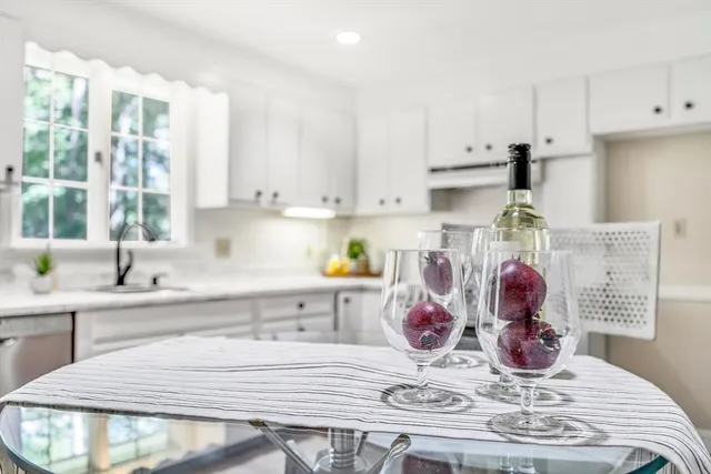 a kitchen with kitchen island stainless steel appliances a stove a sink and white cabinets