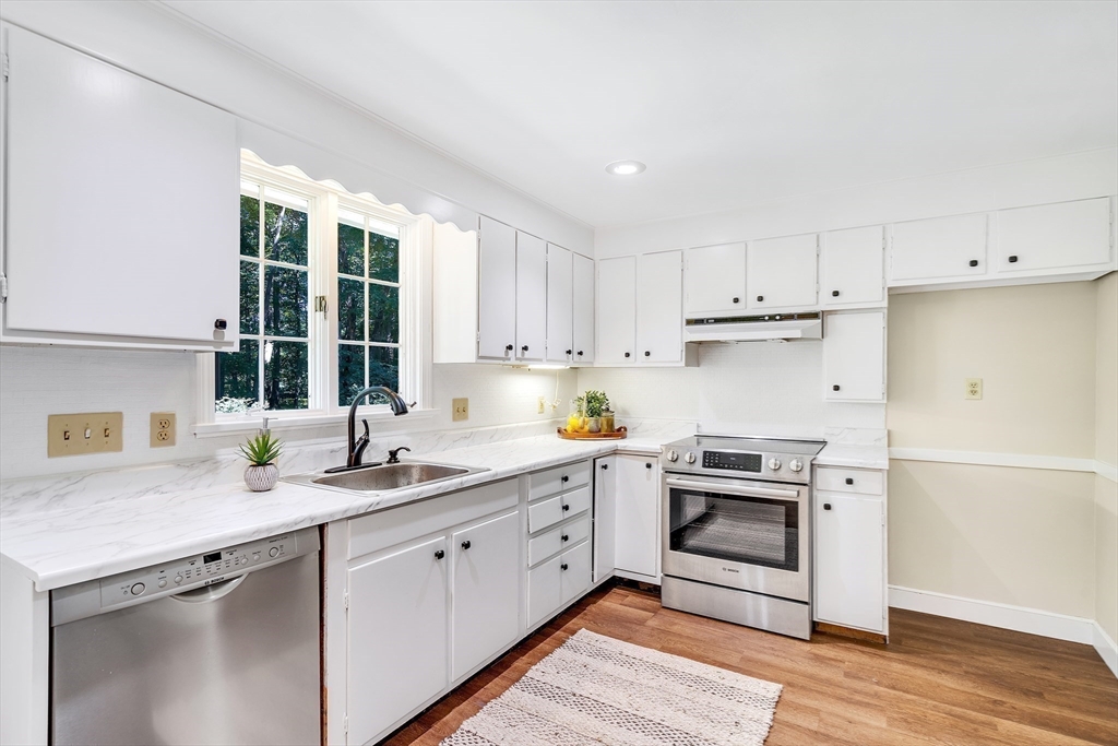 310 Hayward Mill Road Concord, MA 01742 - Photo 15 of 39 a kitchen with a sink white cabinets and white appliances