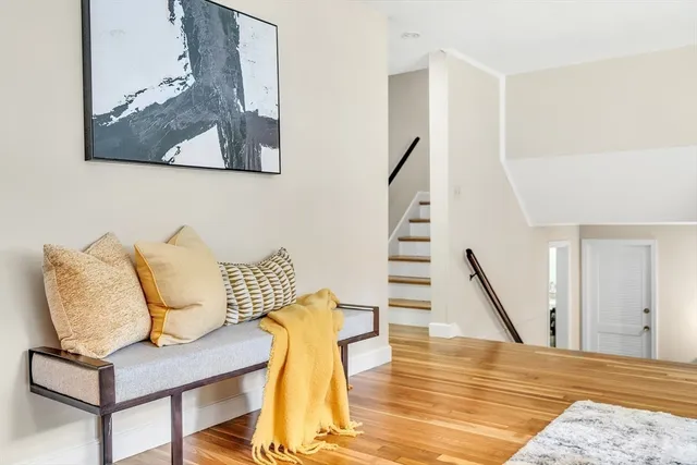 a view of a hallway with furniture and wooden floor