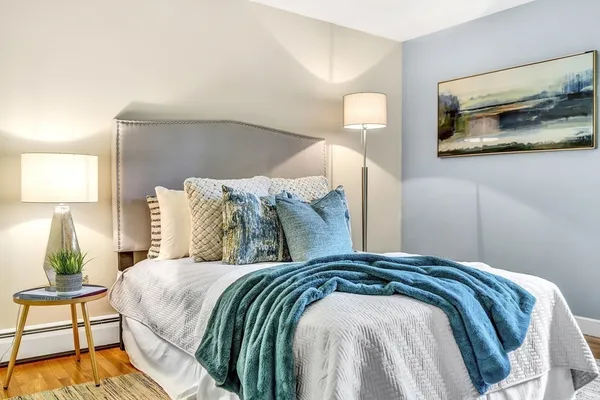 a bedroom with a bed and a painting on the wall