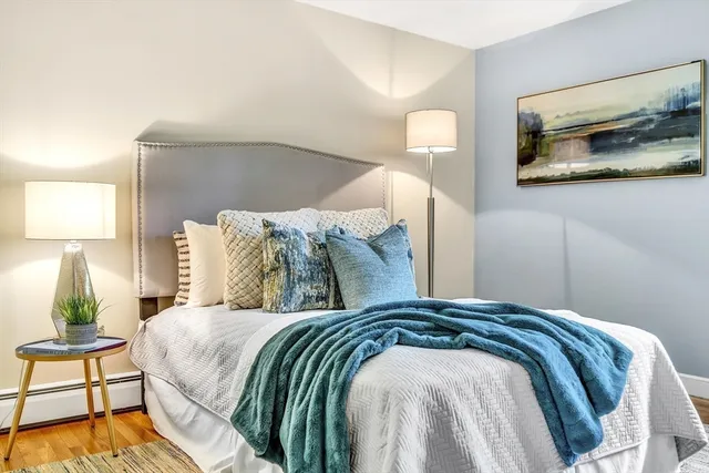 a bedroom with a bed and a painting on the wall