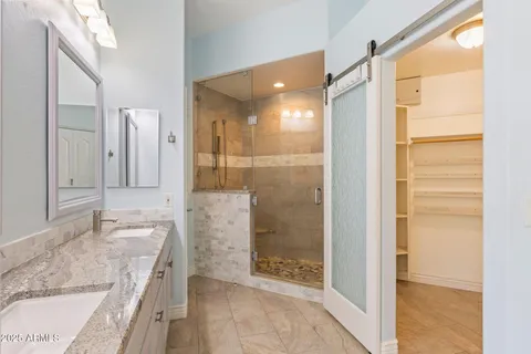 a bathroom with a granite countertop sink a mirror and shower