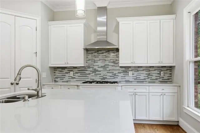 a kitchen with granite countertop white cabinets and sink