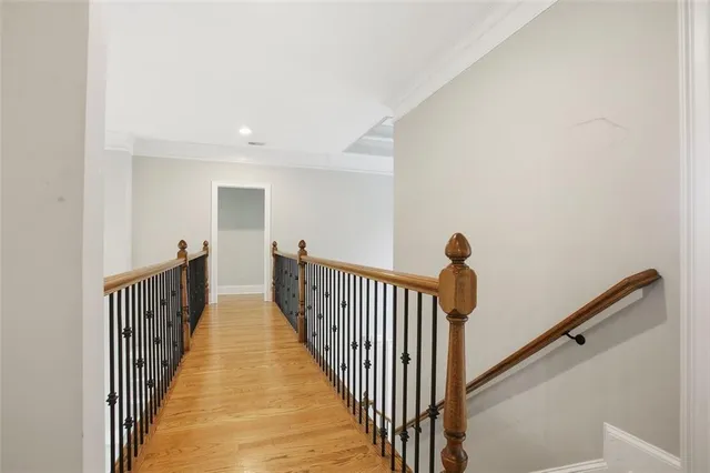 a view of a hallway with wooden floor and stairs