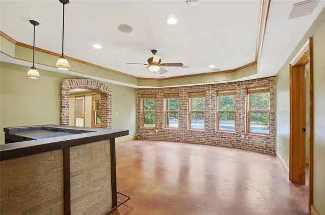 en empty room with windows and ceiling fan