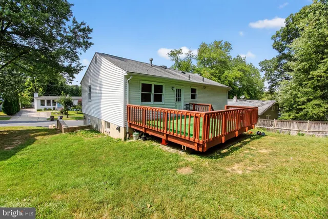 a view of a house with a yard and deck area