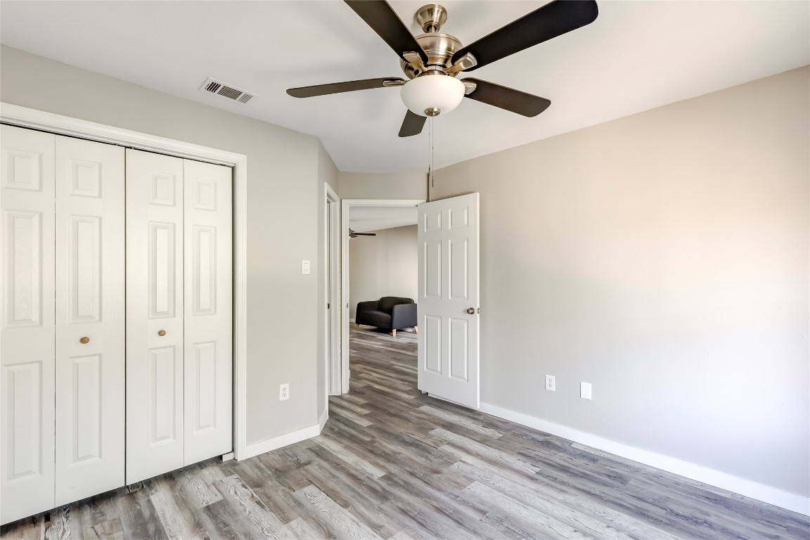 1740 Timber Ridge Road, Unit 136 Austin, TX 78741 - Photo 20 of 32 Unfurnished bedroom with a closet, ceiling fan, and light wood-style floors