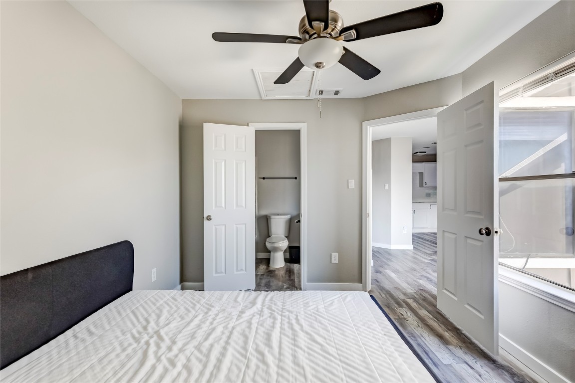 1740 Timber Ridge Road, Unit 136 Austin, TX 78741 - Photo 23 of 32 Bedroom with ensuite bath, wood finished floors, and a ceiling fan