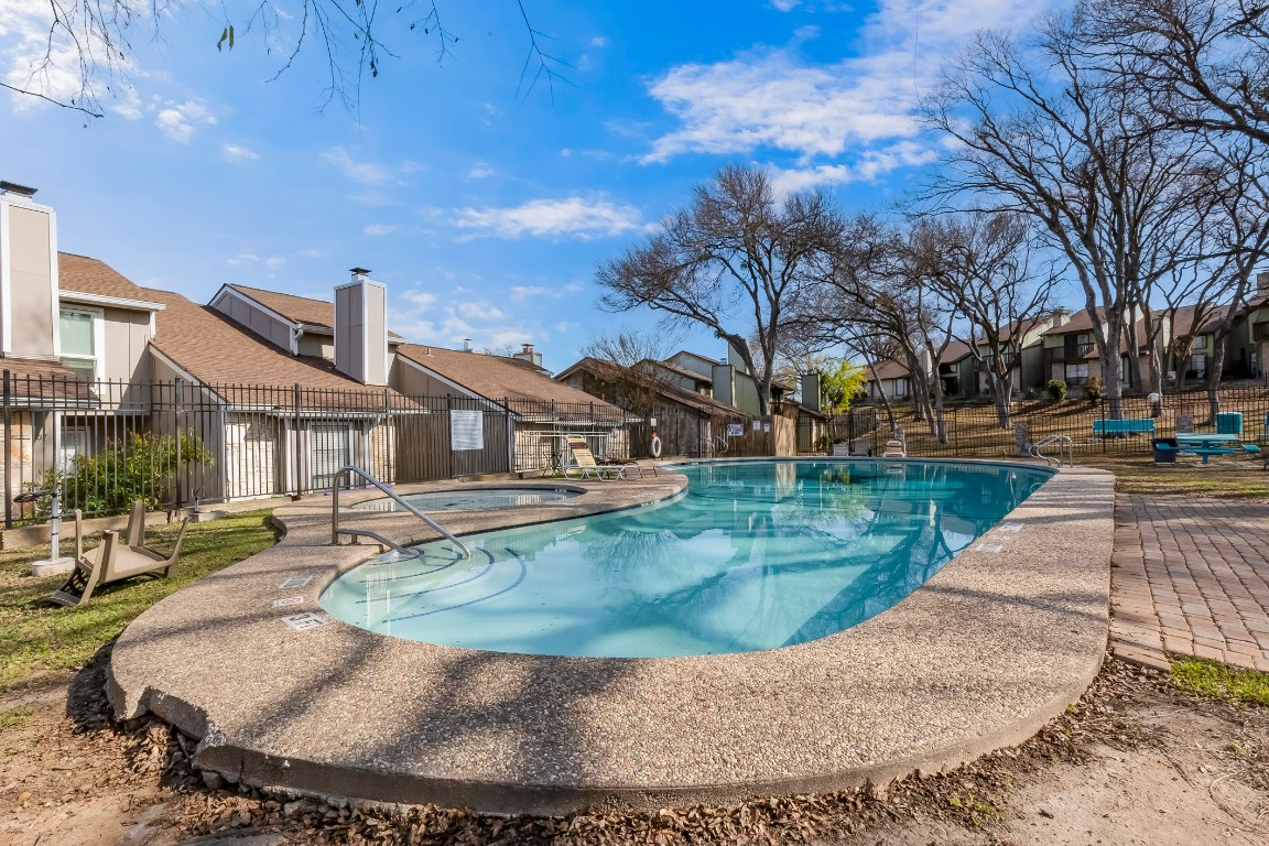 1740 Timber Ridge Road, Unit 136 Austin, TX 78741 - Photo 28 of 32 Community pool featuring a patio area, a residential view, and a hot tub