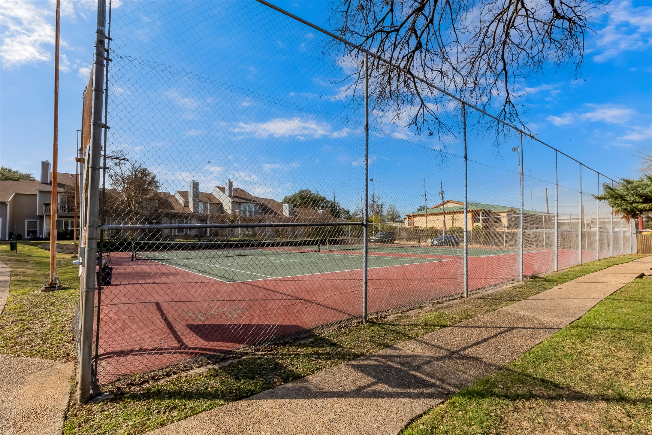 1740 Timber Ridge Road, Unit 136 Austin, TX 78741 - Photo 29 of 32 View of tennis court featuring a residential view
