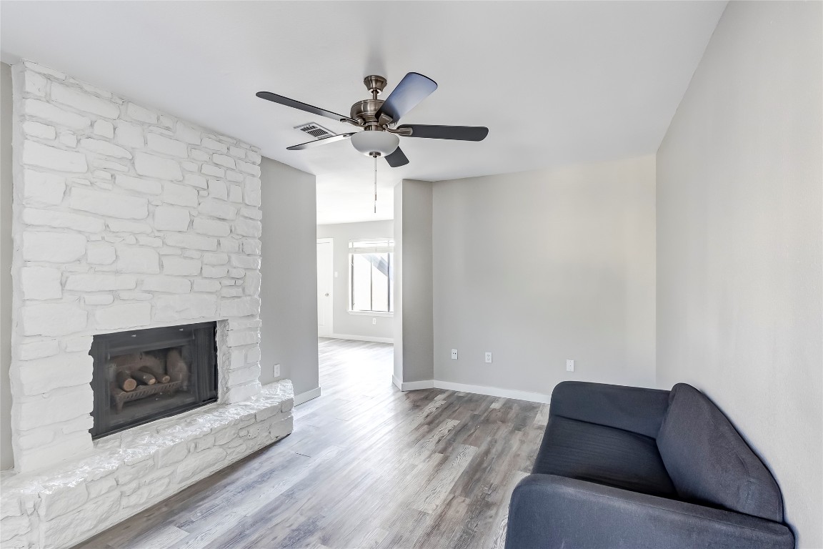 1740 Timber Ridge Road, Unit 136 Austin, TX 78741 - Photo 8 of 32 Living area featuring a fireplace, wood finished floors, and a ceiling fan
