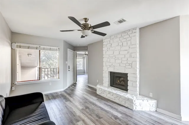 a living room with wooden floor and a fireplace