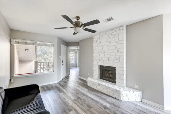 a living room with wooden floor and a fireplace