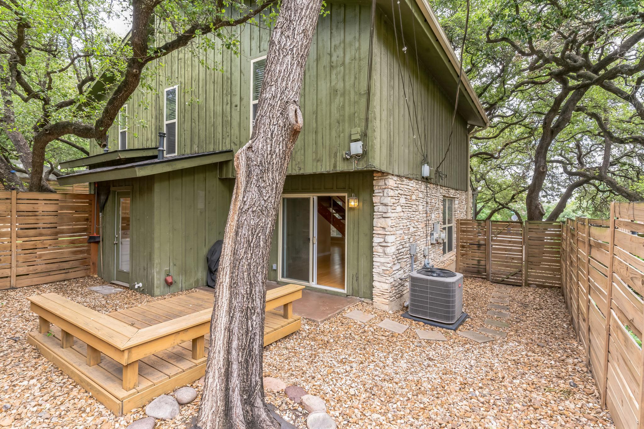 3214 Clawson Road, Unit A Austin, TX 78704 - Photo 25 of 26 A private backyard oasis with built-in seating, rock landscaping, and mature trees offers serene outdoor living.