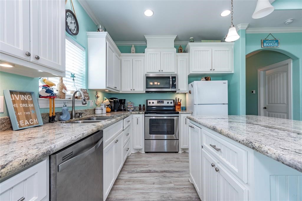 987 Surf Crystal Beach Crystal Beach, TX 77650 - Photo 12 of 45 a kitchen with kitchen island granite countertop a sink a counter space stainless steel appliances and cabinets