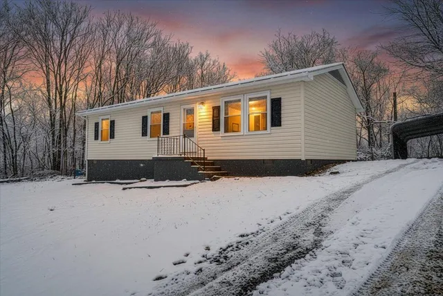 a view of a house with a yard covered in snow