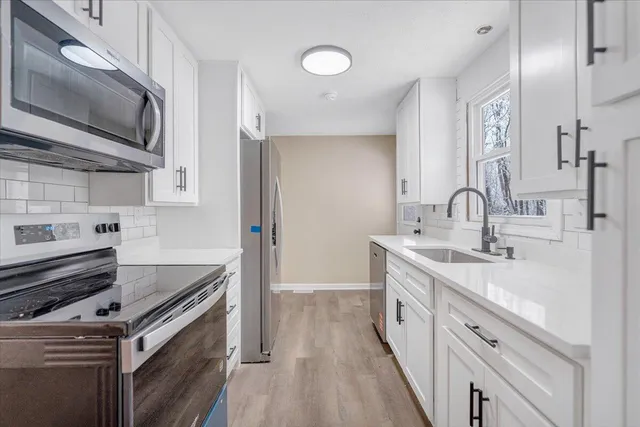 a kitchen with stainless steel appliances granite countertop a sink stove and refrigerator