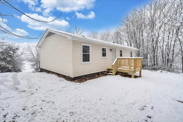 a view of a house with a yard covered in snow