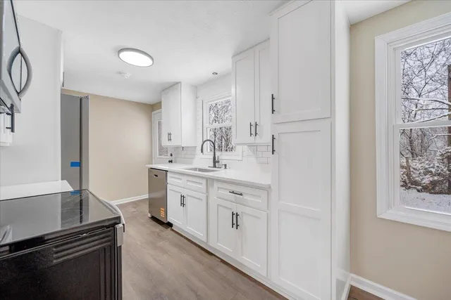 a kitchen with white cabinets and appliances