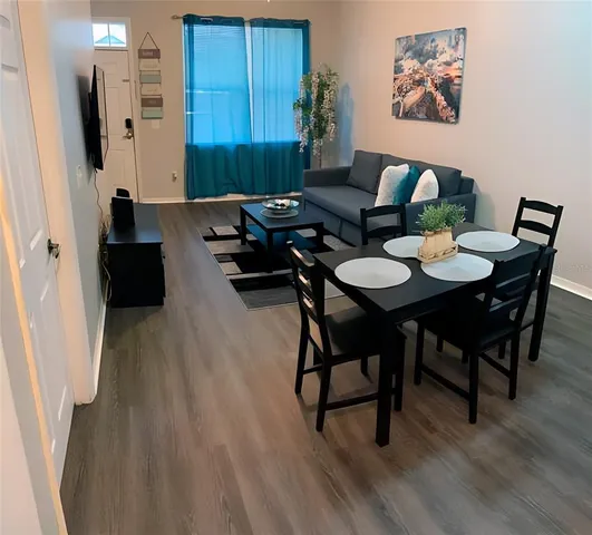 a dinning room with furniture and wooden floor