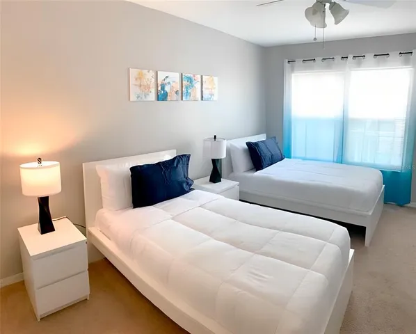 a bedroom with a bed a window and a flat screen tv