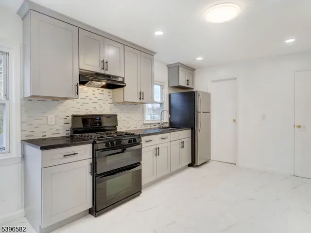 a kitchen with stainless steel appliances granite countertop a stove a sink and a refrigerator
