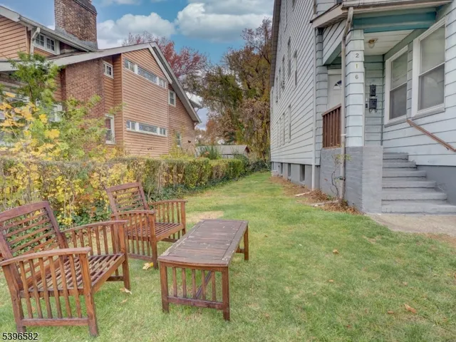 a view of a chair and table in backyard of the house