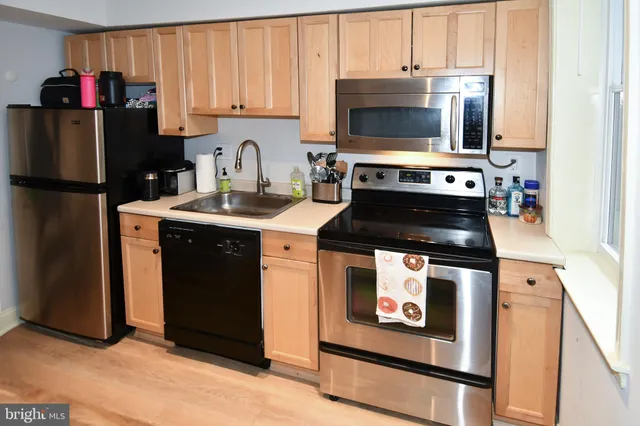a kitchen with stainless steel appliances granite countertop a stove a sink and a refrigerator