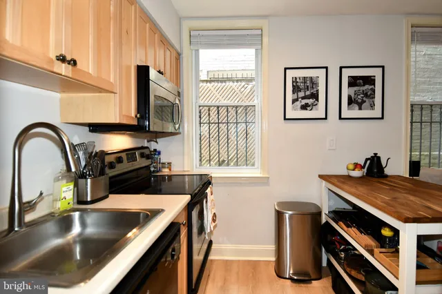 a kitchen with kitchen island a stove and a sink with wooden floor
