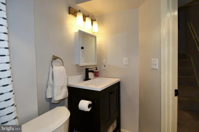 a bathroom with a sink toilet and mirror