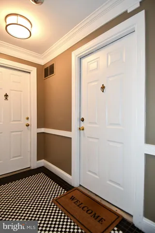 a view of a hallway with wooden floor and a bathroom
