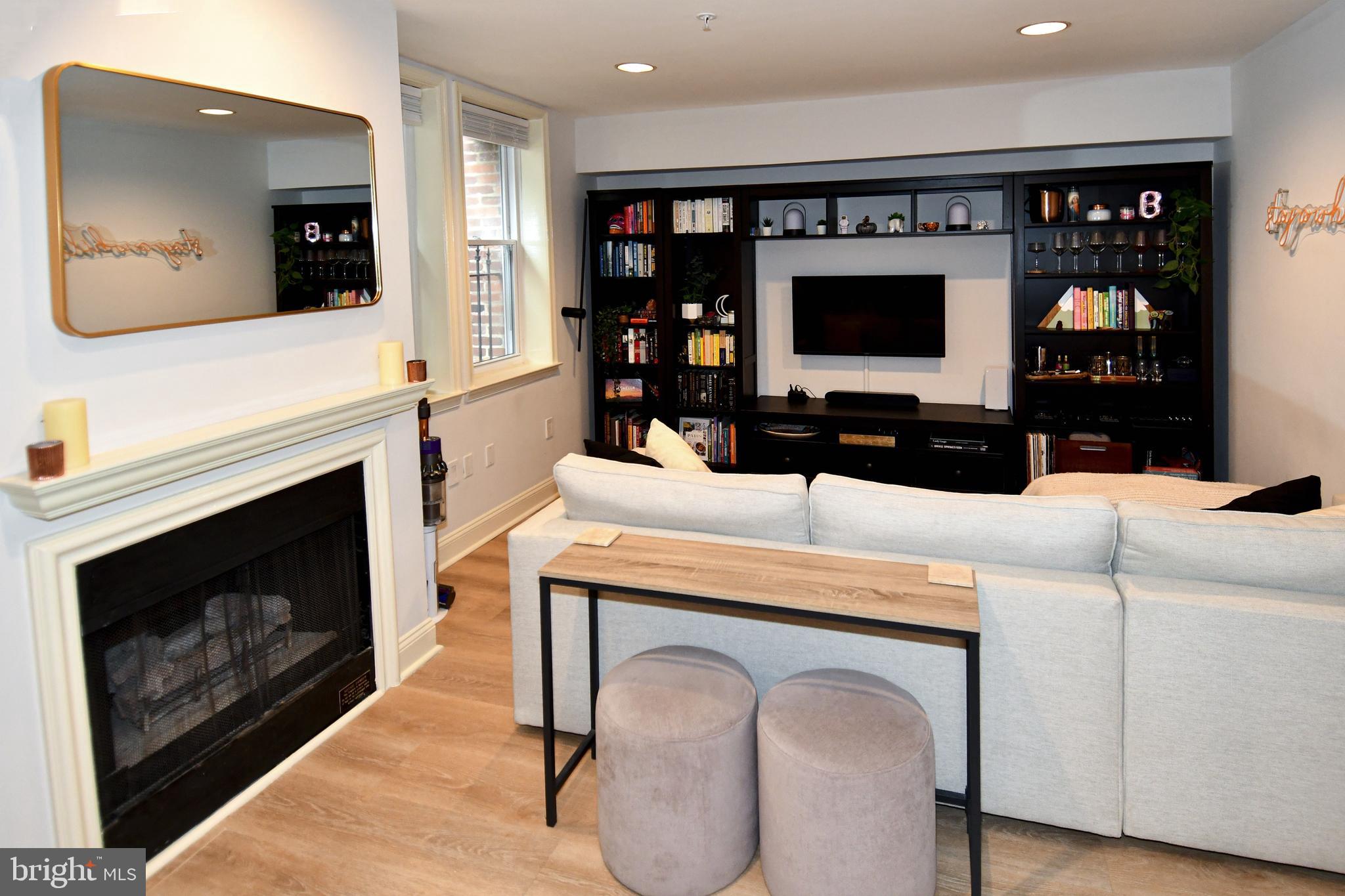 1731 Willard Street Northwest, Unit 105 Washington, DC 20009 - Photo 4 of 52 a living room with furniture a flat screen tv and a fireplace