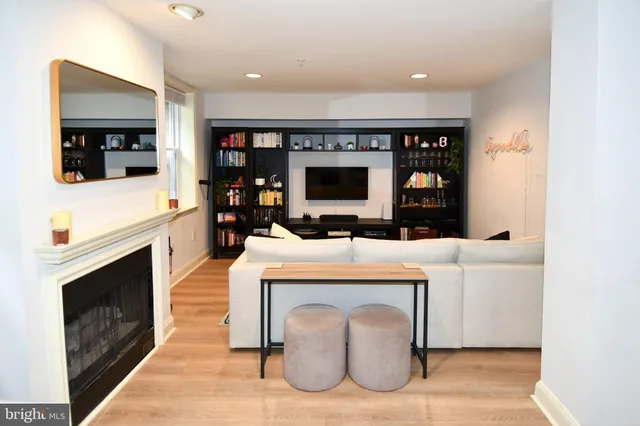 a living room with furniture a flat screen tv and a fireplace