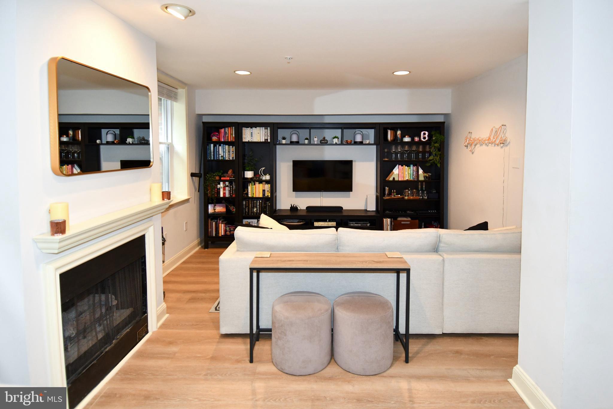 1731 Willard Street Northwest, Unit 105 Washington, DC 20009 - Photo 7 of 52 a living room with furniture a flat screen tv and a fireplace