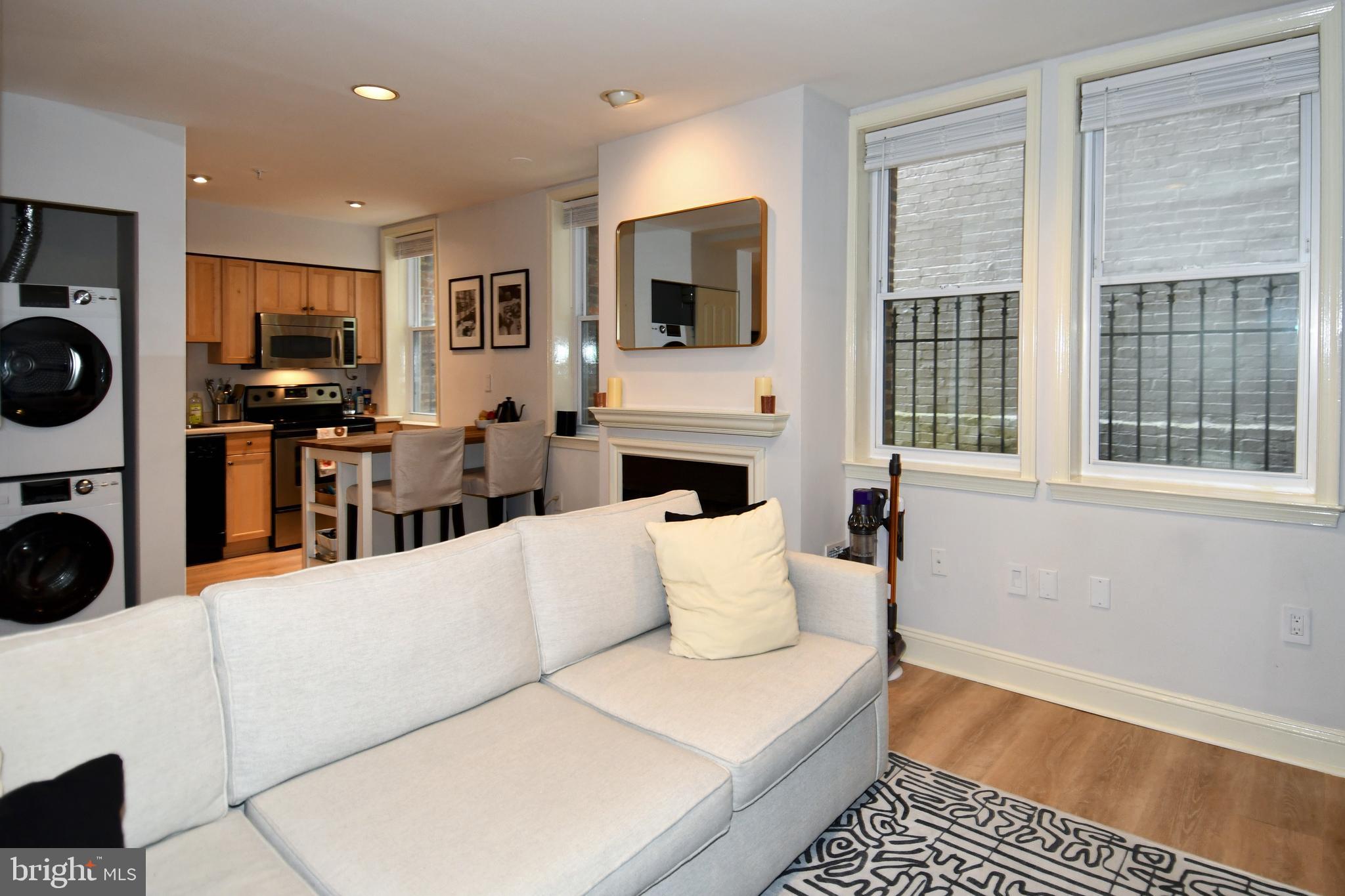 1731 Willard Street Northwest, Unit 105 Washington, DC 20009 - Photo 9 of 52 a living room with furniture a flat screen tv and a fireplace