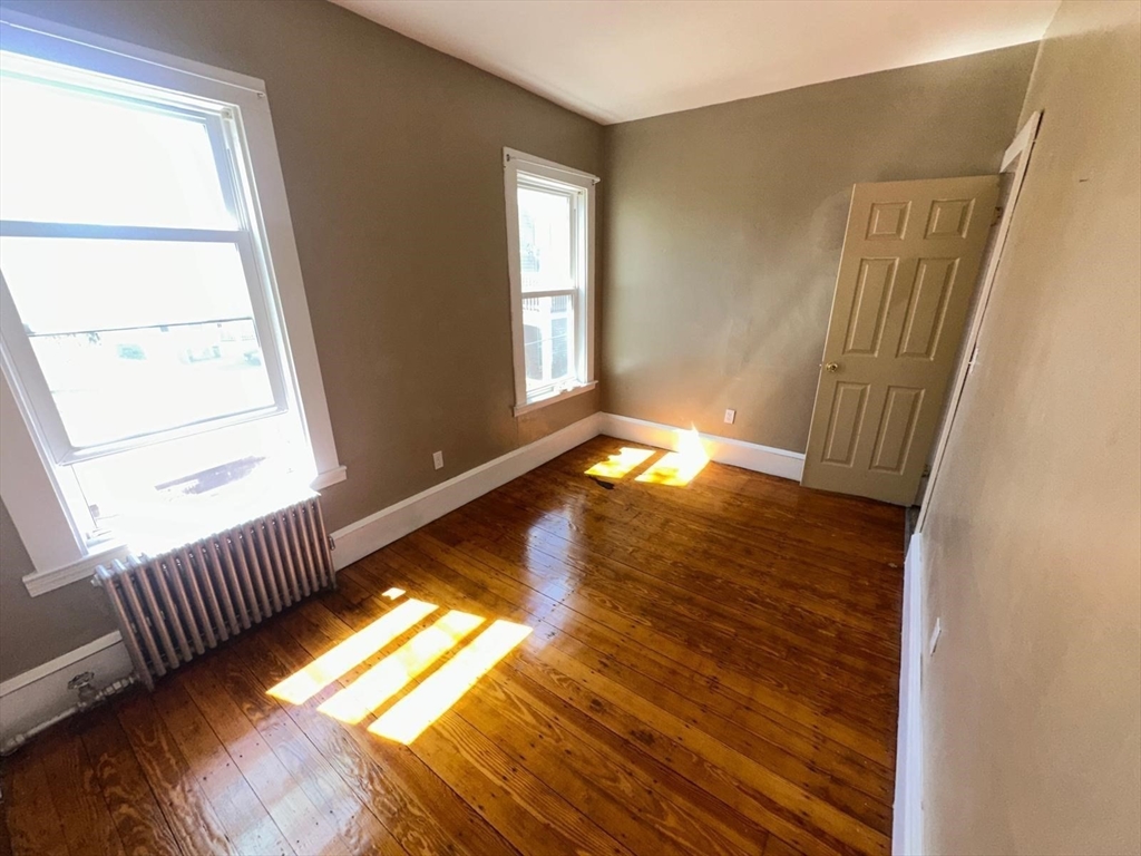 18 Hendry Street, Unit 2 Boston, MA 02122 - Photo 14 of 15 a view of an empty room with wooden floor and a window