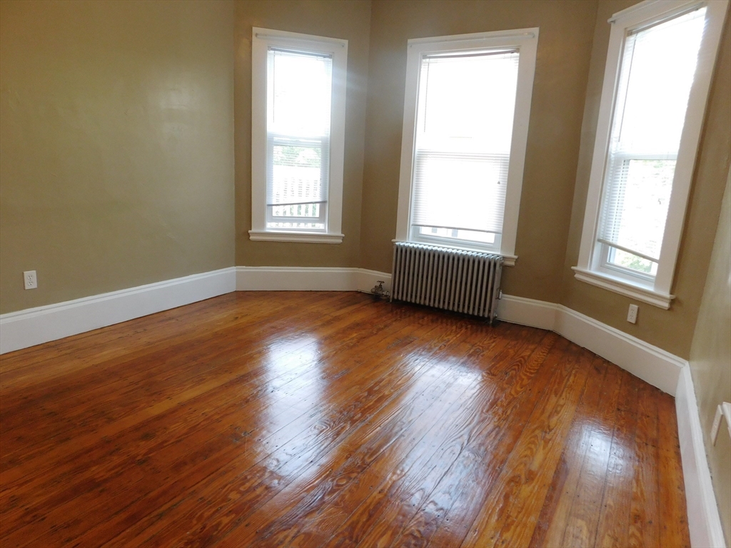 18 Hendry Street, Unit 2 Boston, MA 02122 - Photo 2 of 15 a view of an empty room with wooden floor and a window