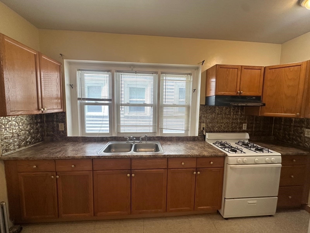18 Hendry Street, Unit 2 Boston, MA 02122 - Photo 3 of 15 a kitchen with granite countertop a sink a stove and cabinets
