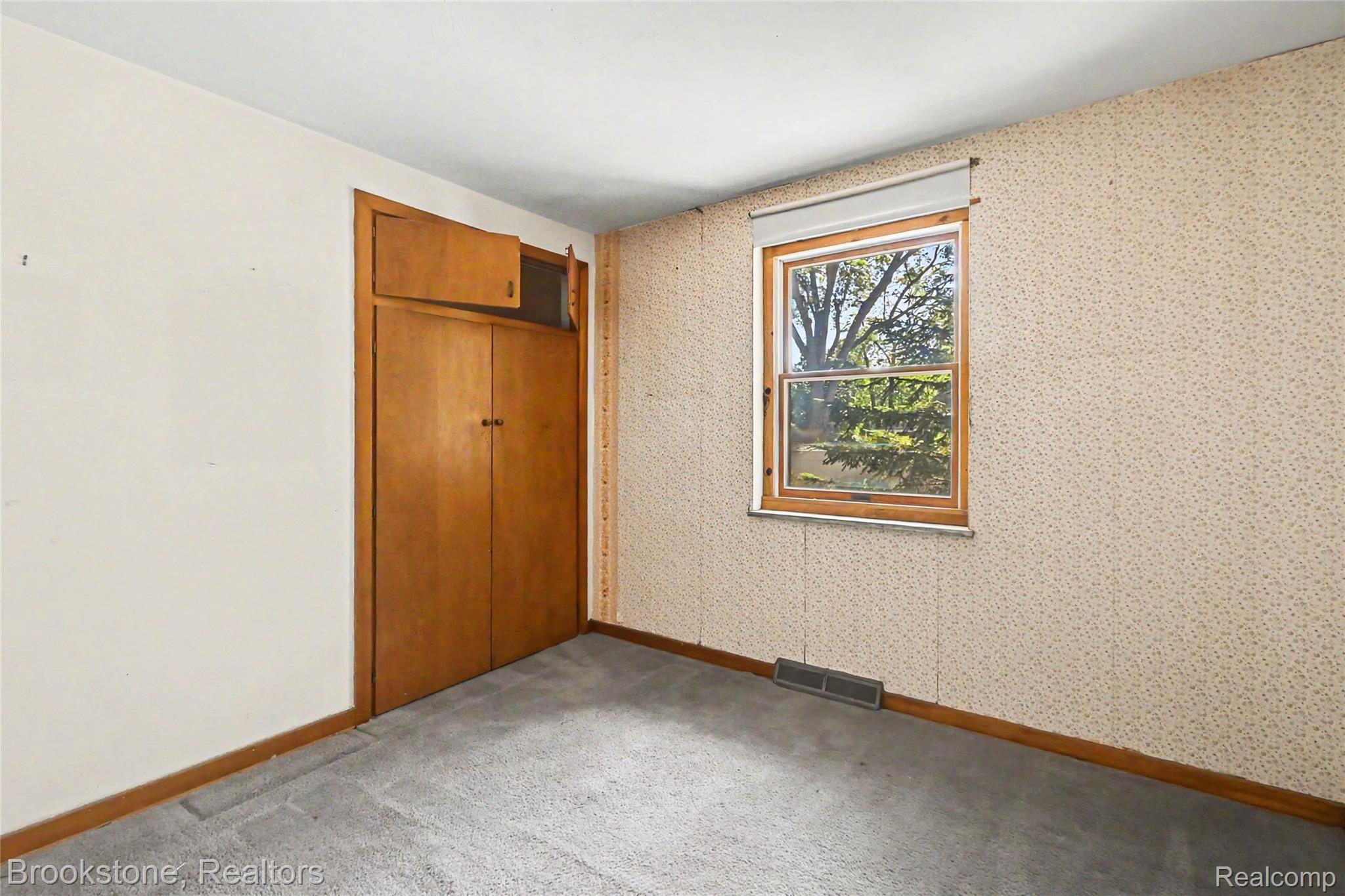 416 East Maple Street Mason, MI 48854 - Photo 11 of 18 Room featuring a window with wood trim, built-in wood cabinetry, and carpet flooring