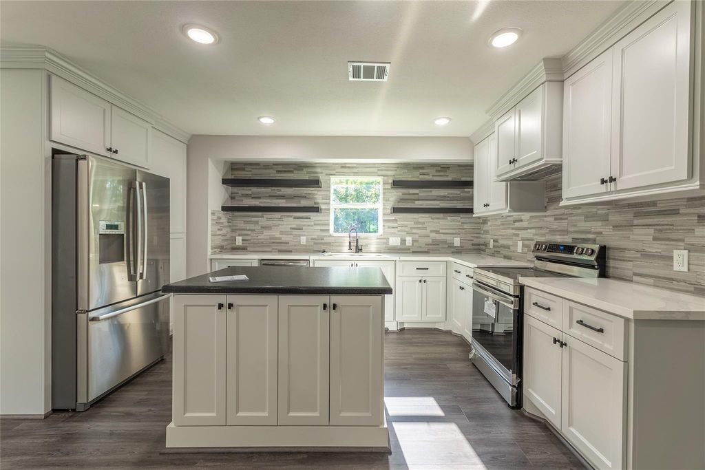 7728 White Rock Road Cleveland, TX 77328 - Photo 15 of 36 a kitchen with stainless steel appliances granite countertop a refrigerator a sink dishwasher a stove and white cabinets with wooden floor