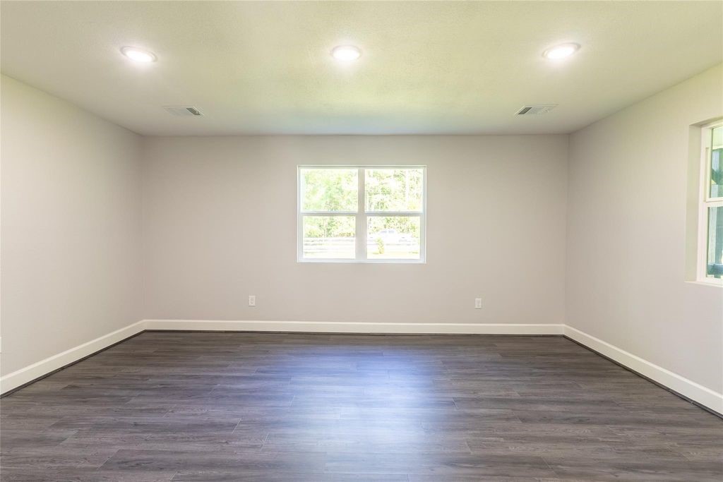 7728 White Rock Road Cleveland, TX 77328 - Photo 18 of 36 an empty room with wooden floor and windows